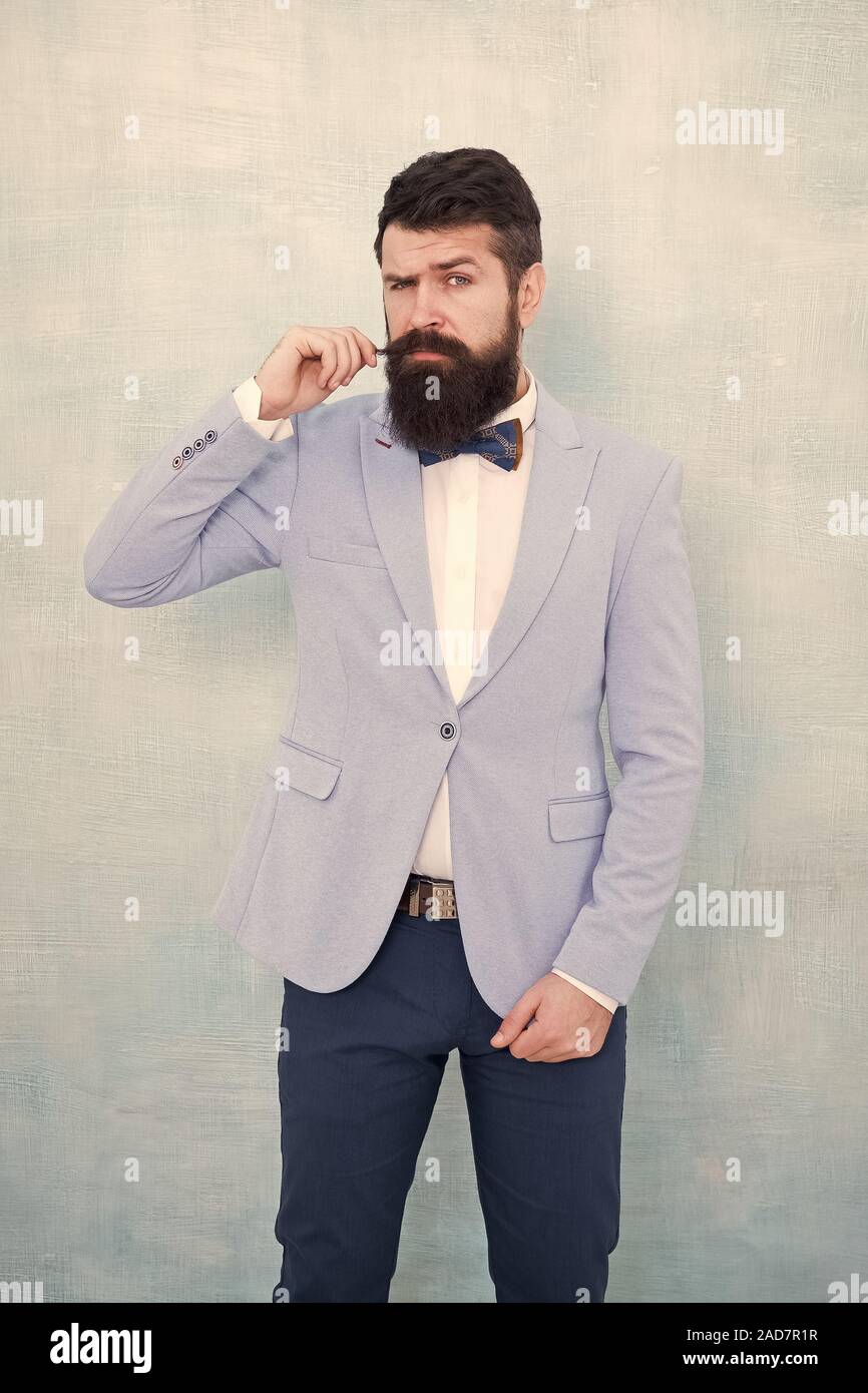 Stylist fashion expert. Suit style. Fashion trends for groom. Groom bearded  hipster man wear light blue tuxedo and bow tie. Wedding day. Stylish groom.  Statement with his stunning crisp suit jacket Stock