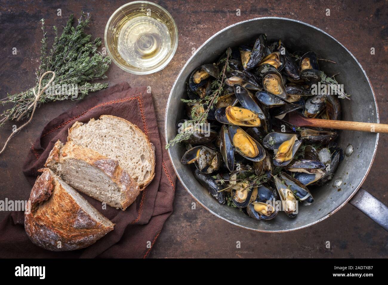 Traditional barbecue Italian blue mussel with farmhouse bread and white wine as top view in a casserole Stock Photo