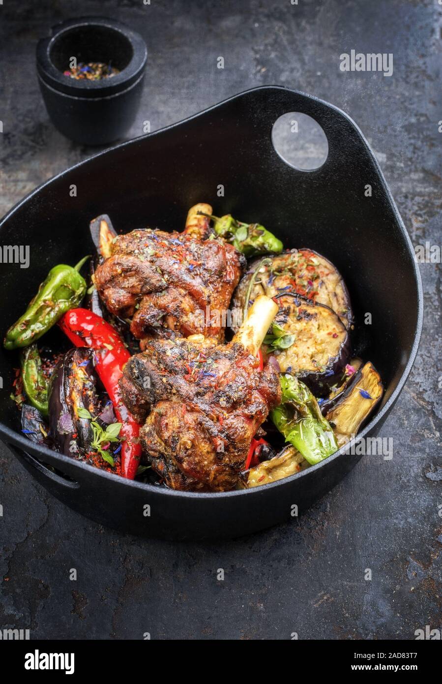 Traditional barbecue leg of lamb with eggplant and chili as top view in