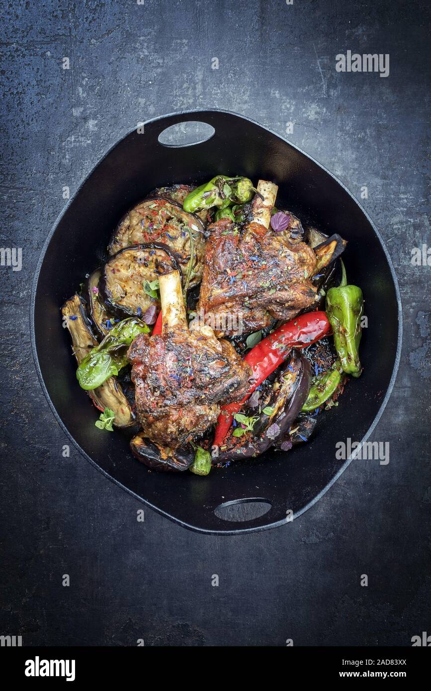 Traditional barbecue leg of lamb with eggplant and chili as top view in