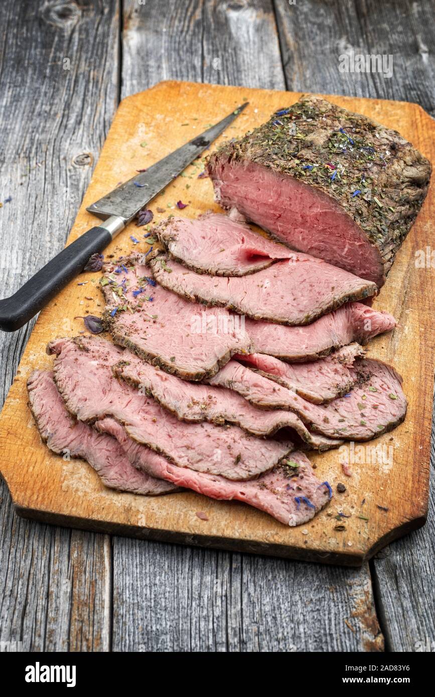 Traditional lunch meat with sliced cold cuts roast beef  as closeup on a cutting board Stock Photo