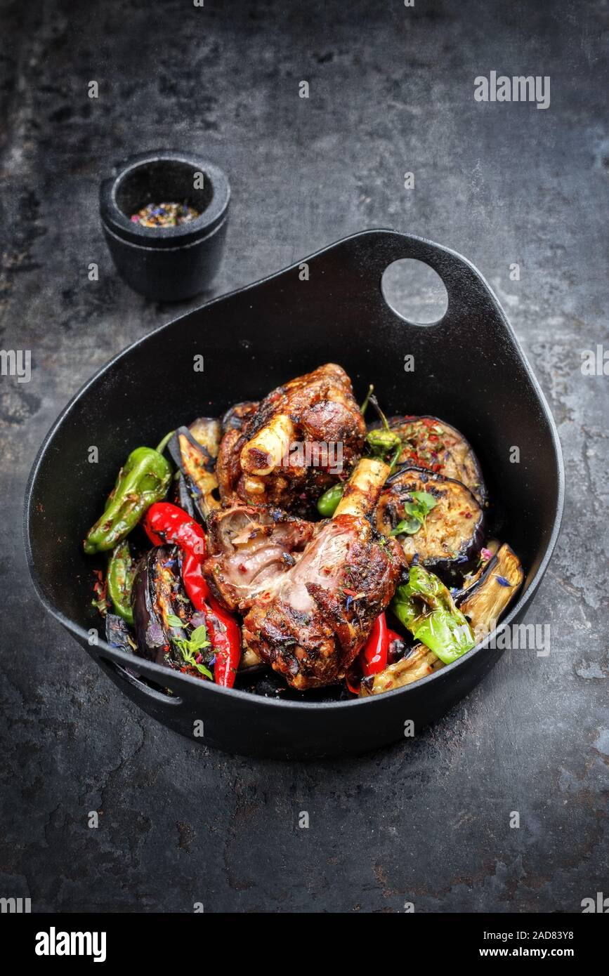 Traditional barbecue leg of lamb with eggplant and chili as top view in