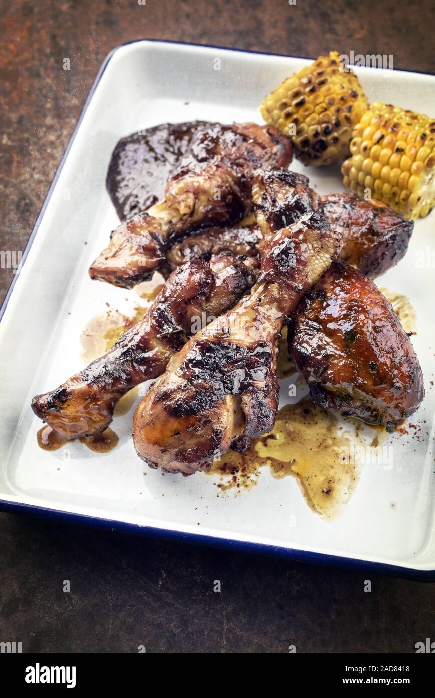 Traditional barbecue chicken drumsticks with corm and hot chili sauce