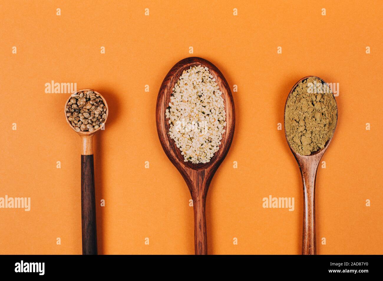 Different types of uses for hemp. Seeds, protein and powder in wooden spoons. Stock Photo
