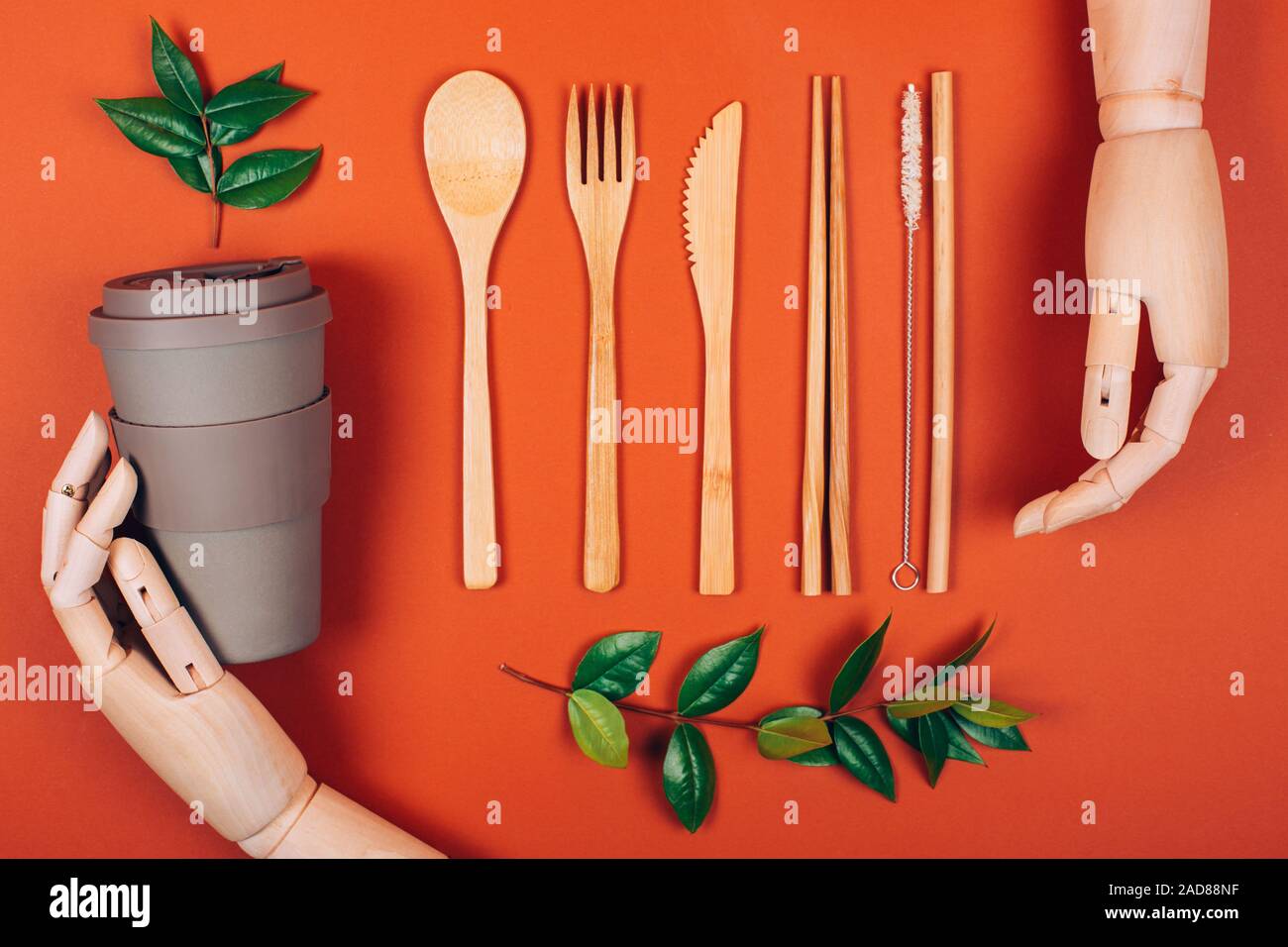 Wooden hand holding reusable picnic tableware. Concept of plasticfree