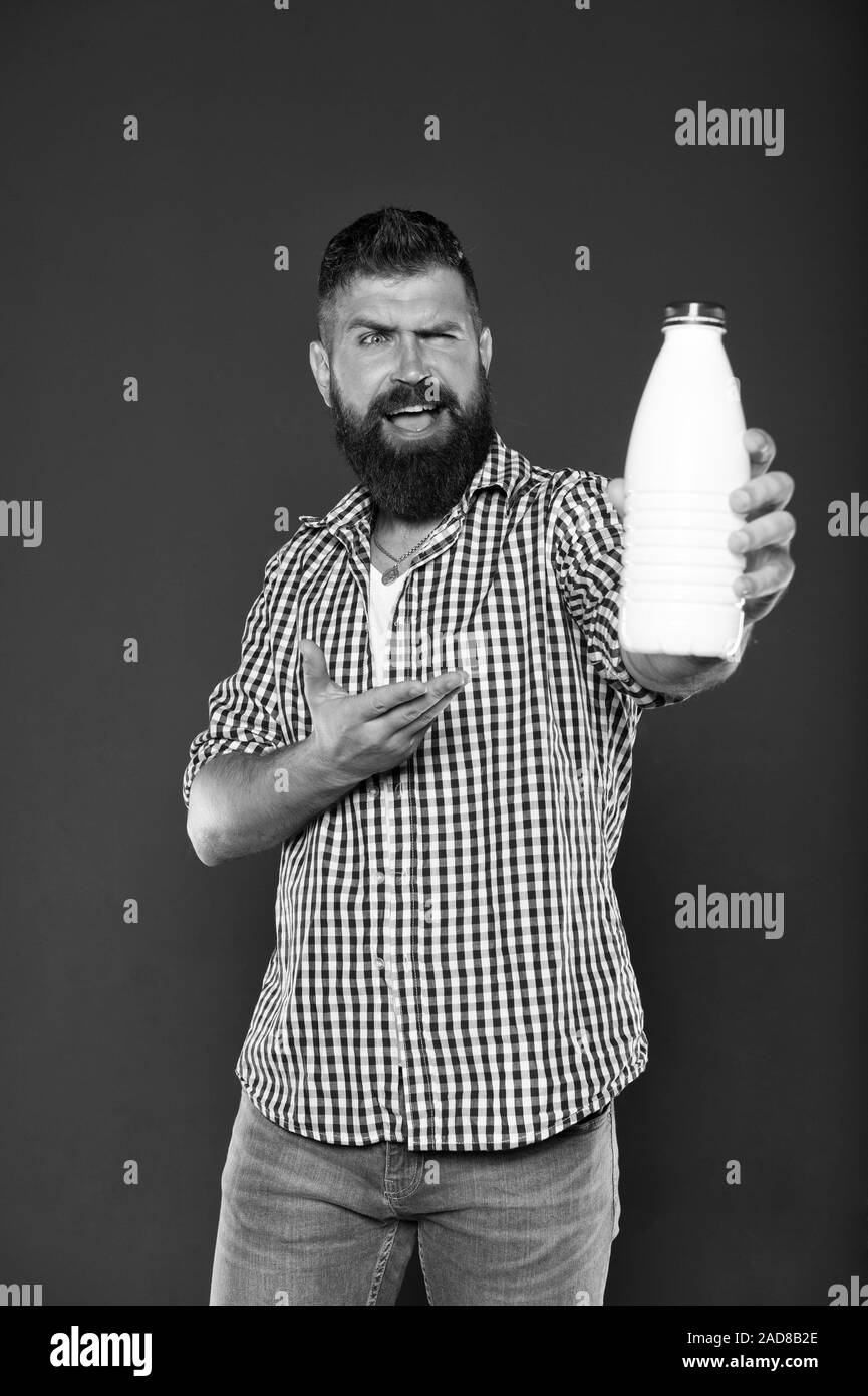 Healthy drinking habits. Happy hipster pointing at bottle for drinking