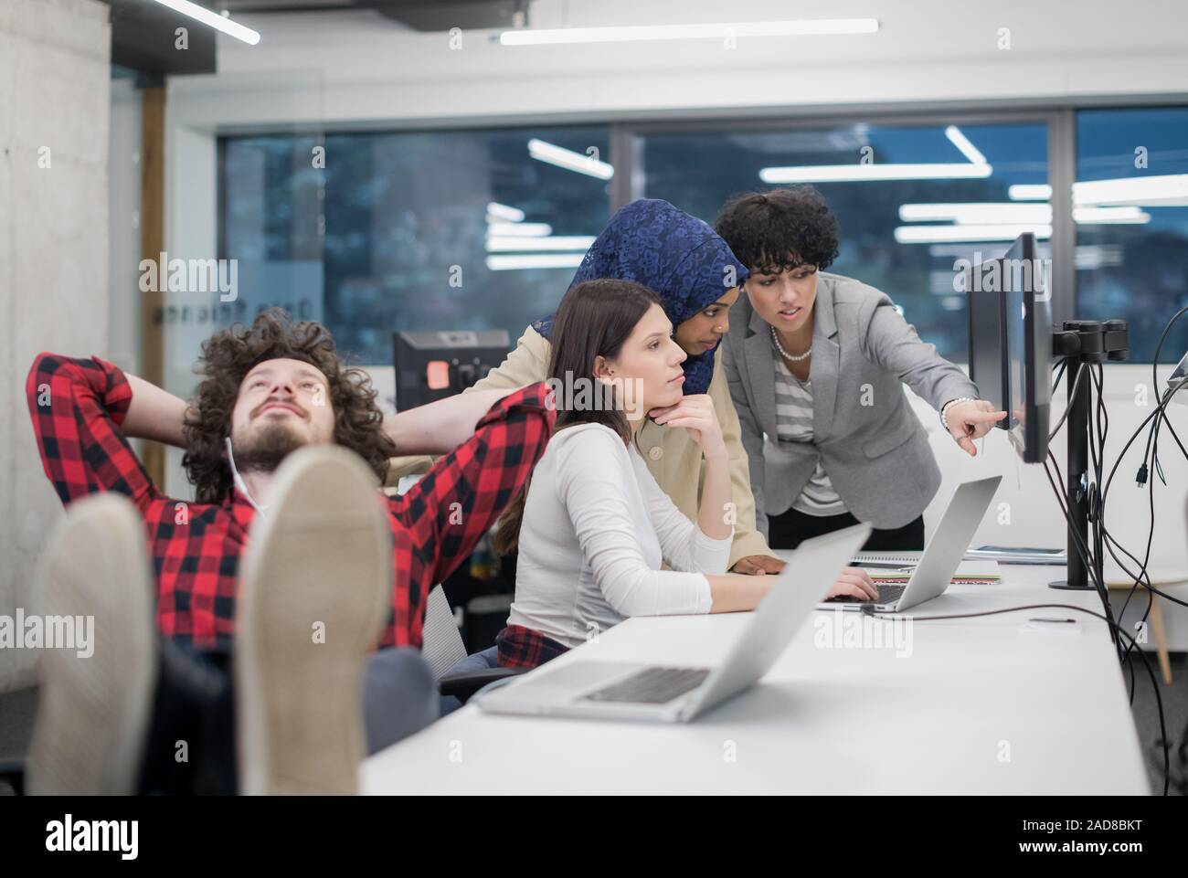 software developer resting with legs on desk Stock Photo