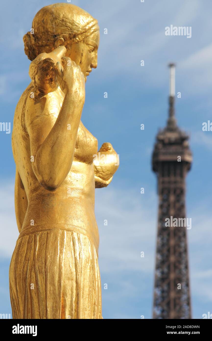 Gold figure in front of Eiffel Tower Stock Photo