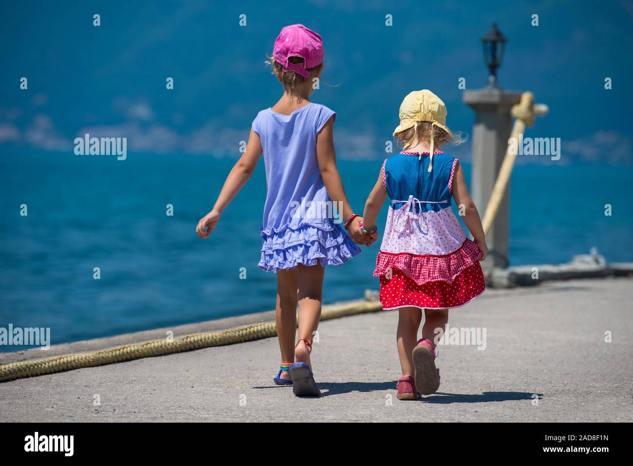 little sisters walking on the beach coast Stock Photo