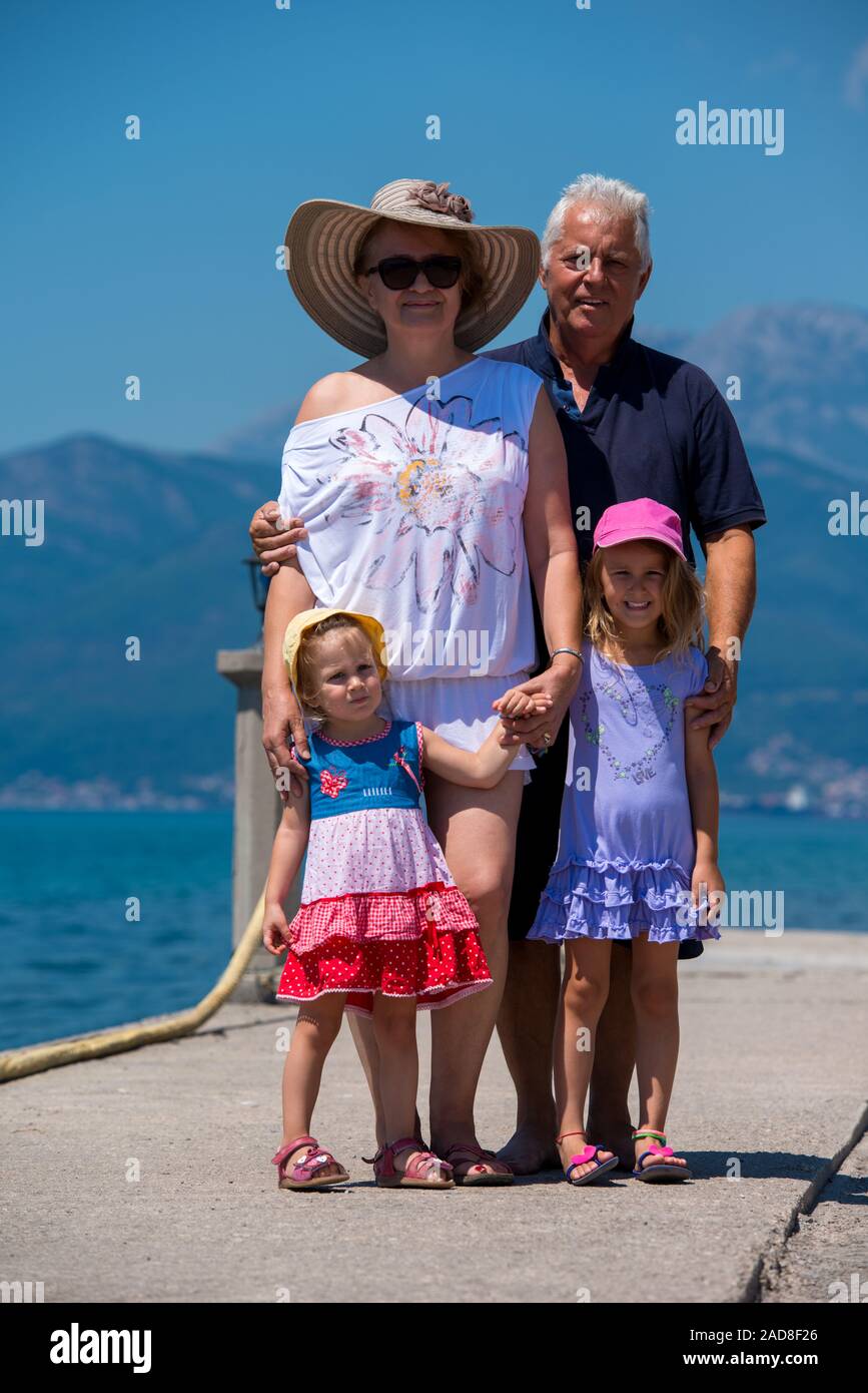 portrait of grandparents and granddaughters standing by the sea Stock Photo