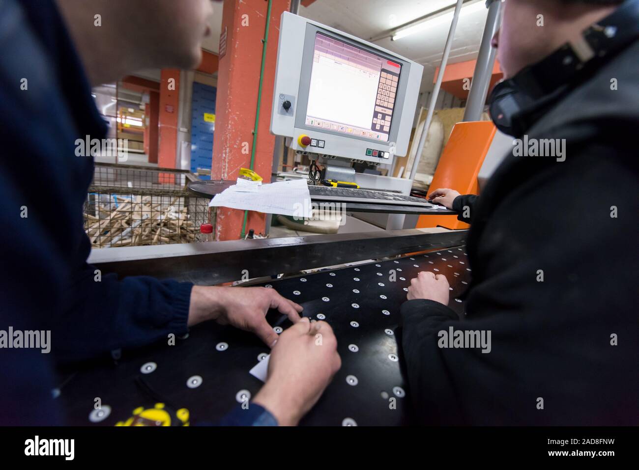 carpenters calculating and programming a cnc wood working machine Stock Photo