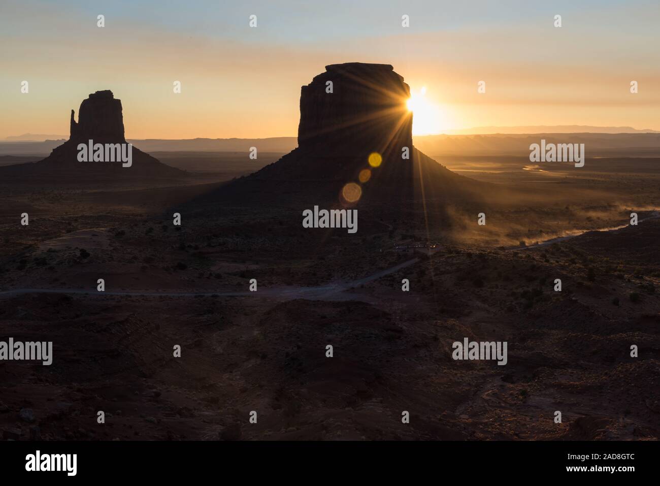 Sunrise flares behind the buttes in Monument Valley, Arizona, US Stock Photo