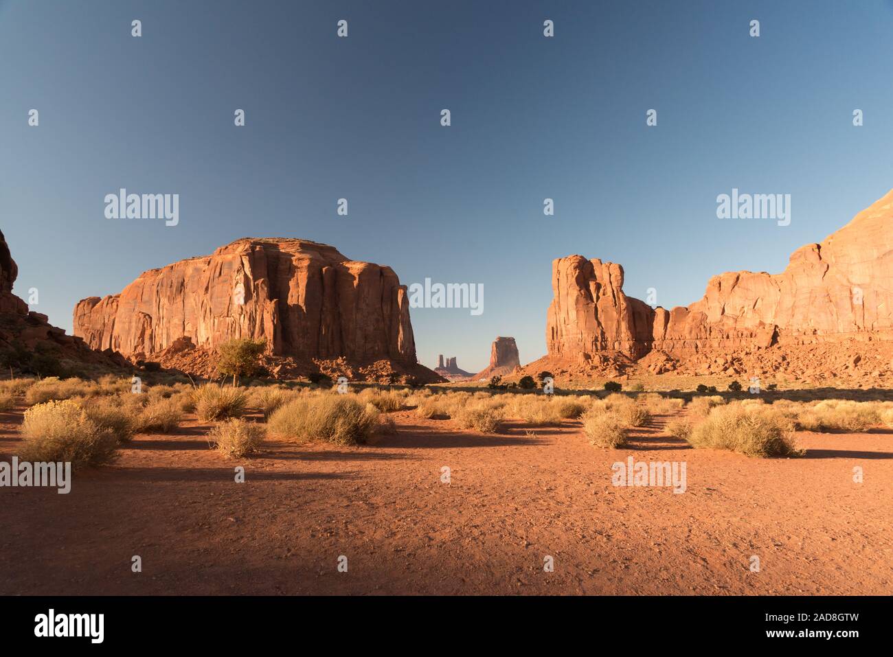 A sunset view of the arid lands in Monument Valley with the mesas at