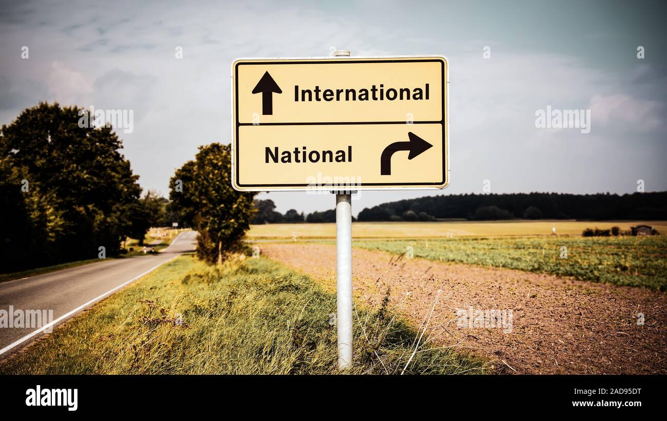 Street Sign to International versus National Stock Photo