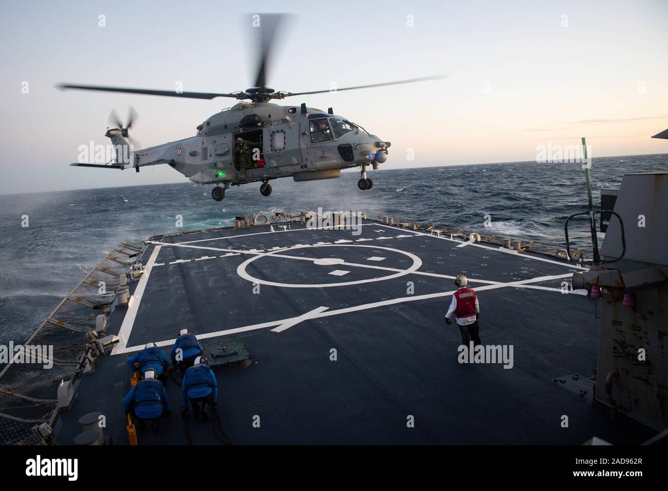 191129-N-CJ510-0276 MEDITERRANEAN SEA (Nov. 29, 2019) – A French helicopter prepares to land on the flight deck of the Arleigh Burke-class guided-missile destroyer USS Ross (DDG 71) during exercise PEAN 19 Nov. 29, 2019. Exercise PEAN 19 is a French-led exercise designed to enhance the operational capability of the French carrier strike group, Charles de Gaulle, while providing realistic training to both the French and participating nations while strengthening interoperability and relationships. (U.S. Navy photo by Mass Communication Specialist 3rd Class Andrea Rumple/Released) Stock Photo