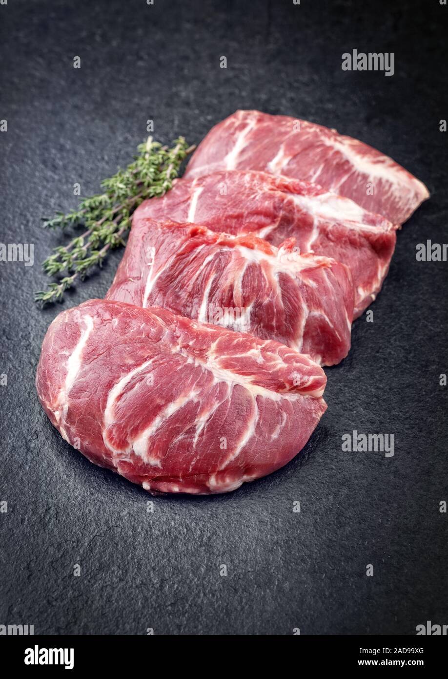 Traditional German raw pork cheeks with hers as closeup on a black