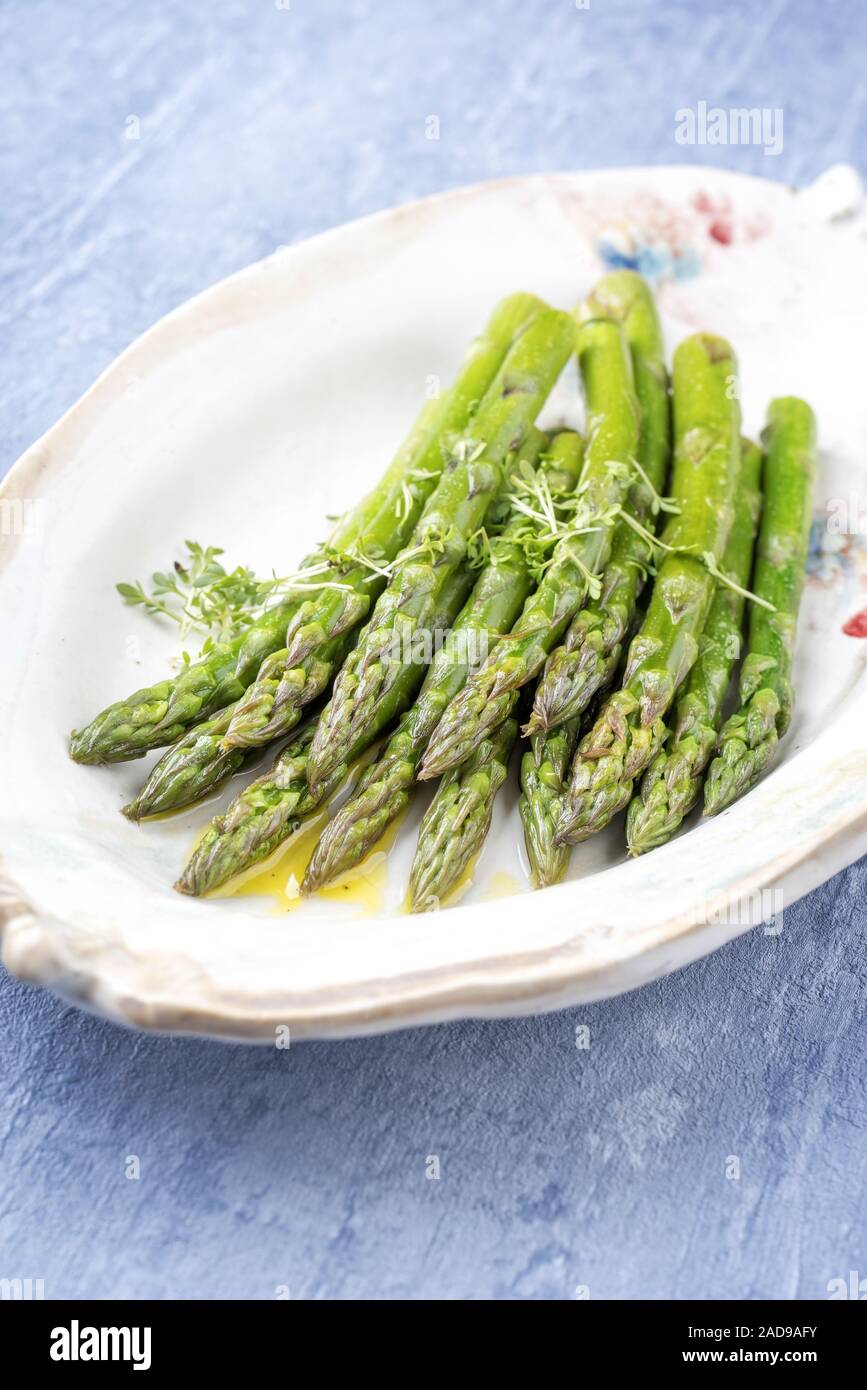 Traditional boiled green asparagus with butter sauce decorated with