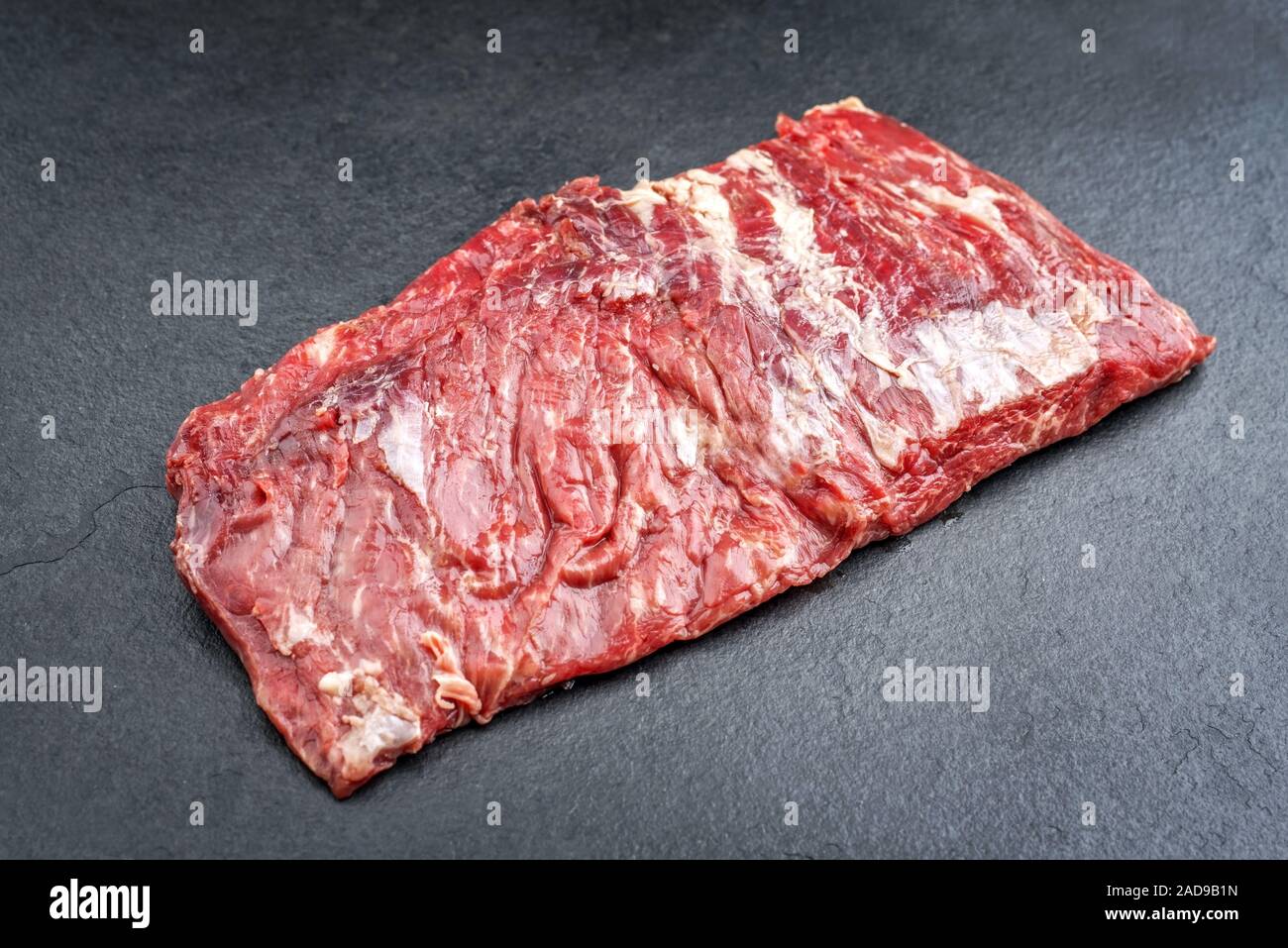 Raw wagyu bavette de flanchet steak offered as top view on a black