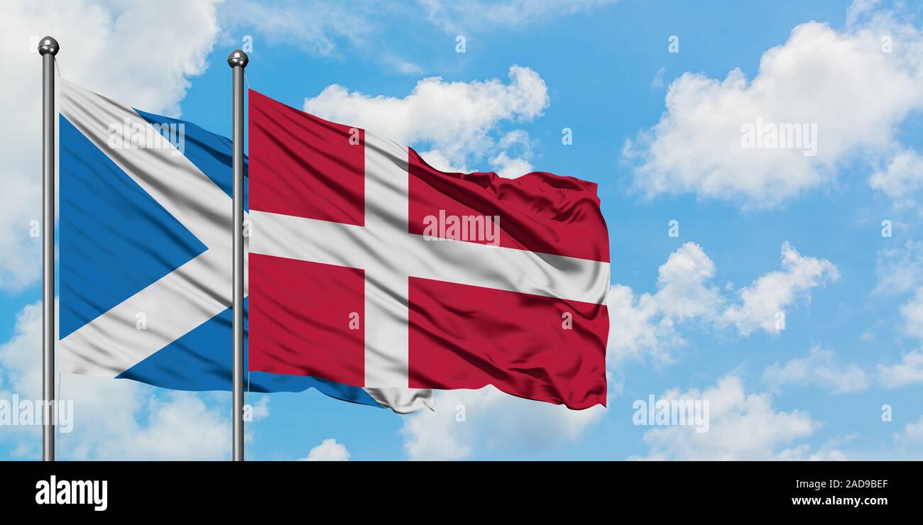 Scotland and Denmark flag waving in the wind against white cloudy blue sky together. Diplomacy concept, international relations. Stock Photo