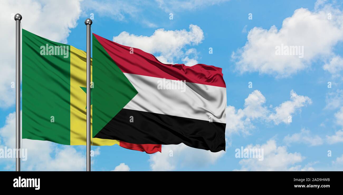 Senegal and Sudan flag waving in the wind against white cloudy blue sky ...