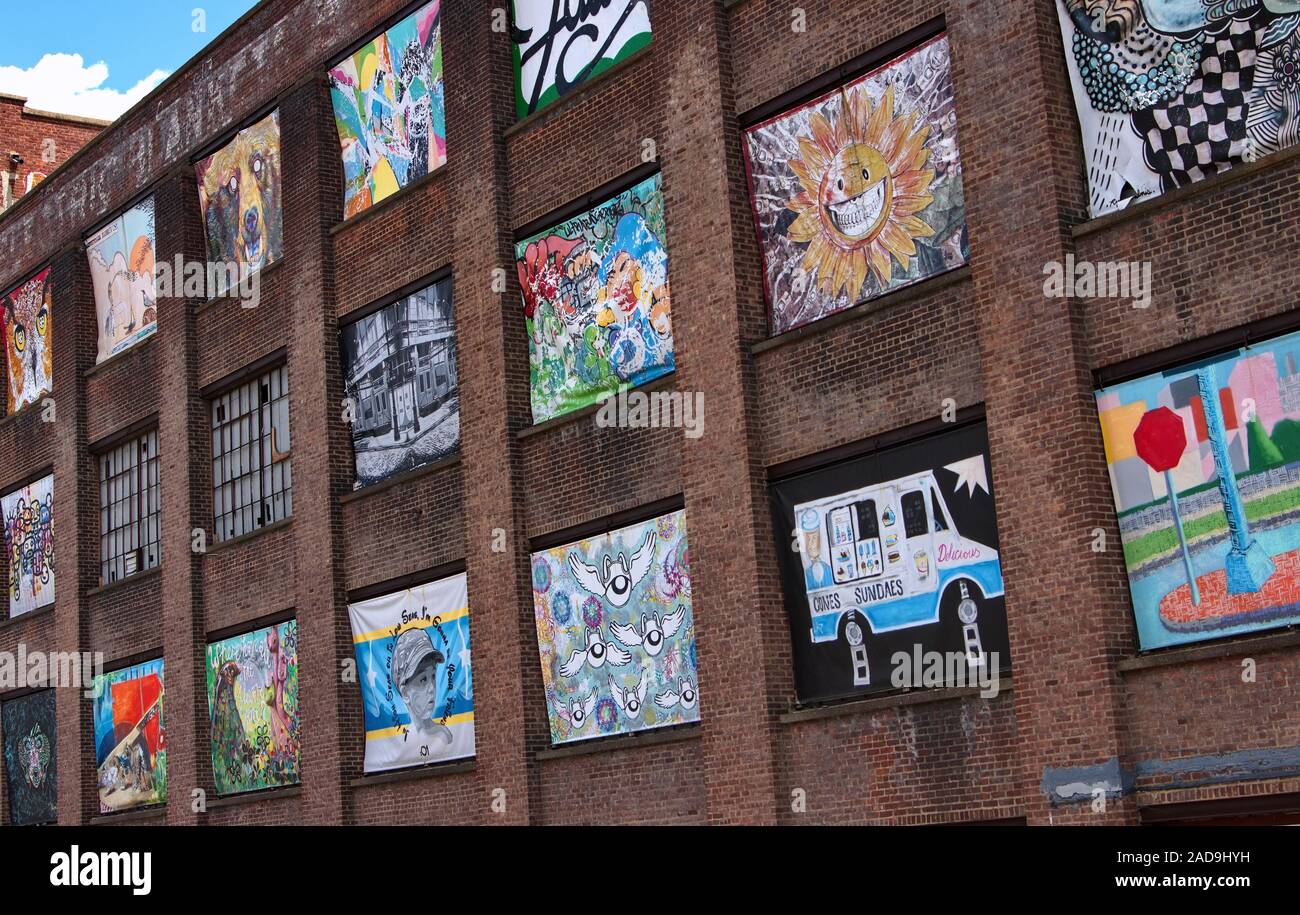 Beacon, NY USA. Jul 2015. Artwork plastered all over windows on this old brick factory. Stock Photo