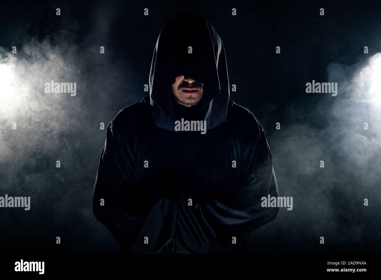 Man dressed in a dark robe looking like a cult leader on a smoky or foggy  background. He looks like a creepy evil villain Stock Photo - Alamy