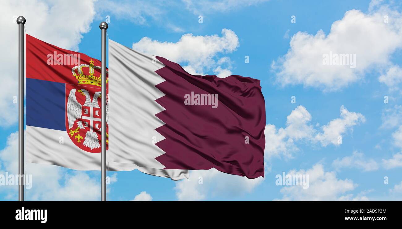 Serbia and Qatar flag waving in the wind against white cloudy blue sky together. Diplomacy concept, international relations. Stock Photo
