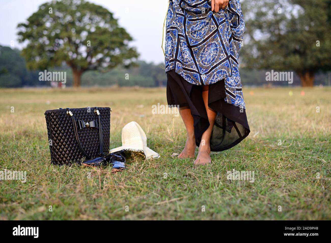 Woman walking barefoot on green grass. Stock Photo