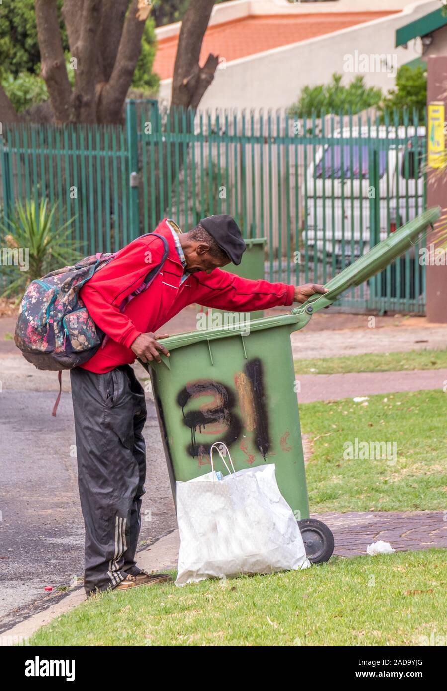 Alberton, South Africa unidentified elderly black man digs in garbage