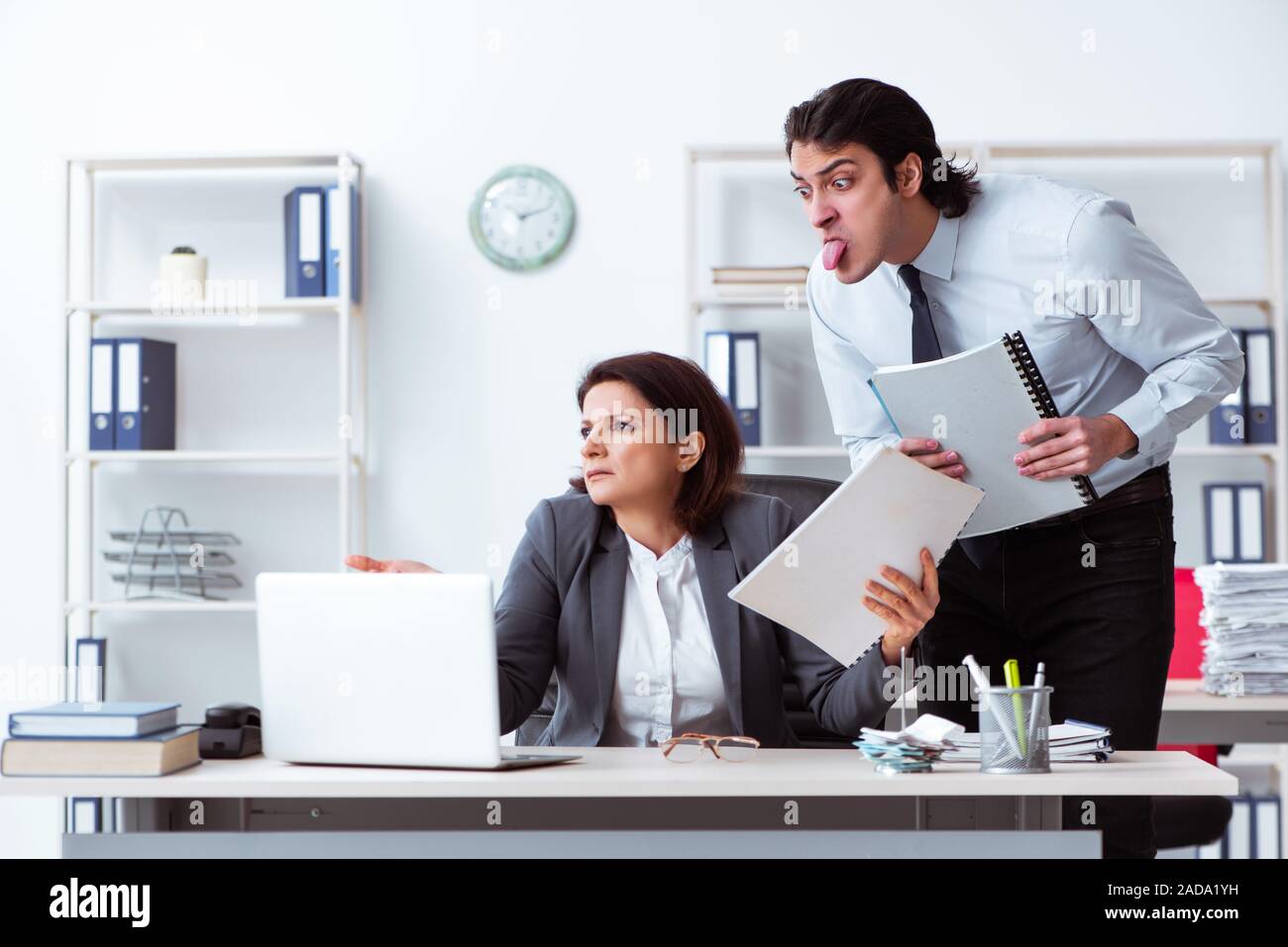 Old female boss and young male employee in the office Stock Photo - Alamy