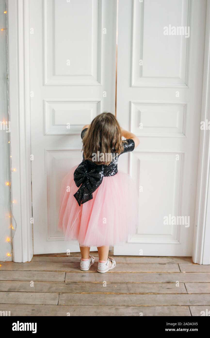 Little Girl In Beautiful Pink Dress With Tutu Skirt Looks At The