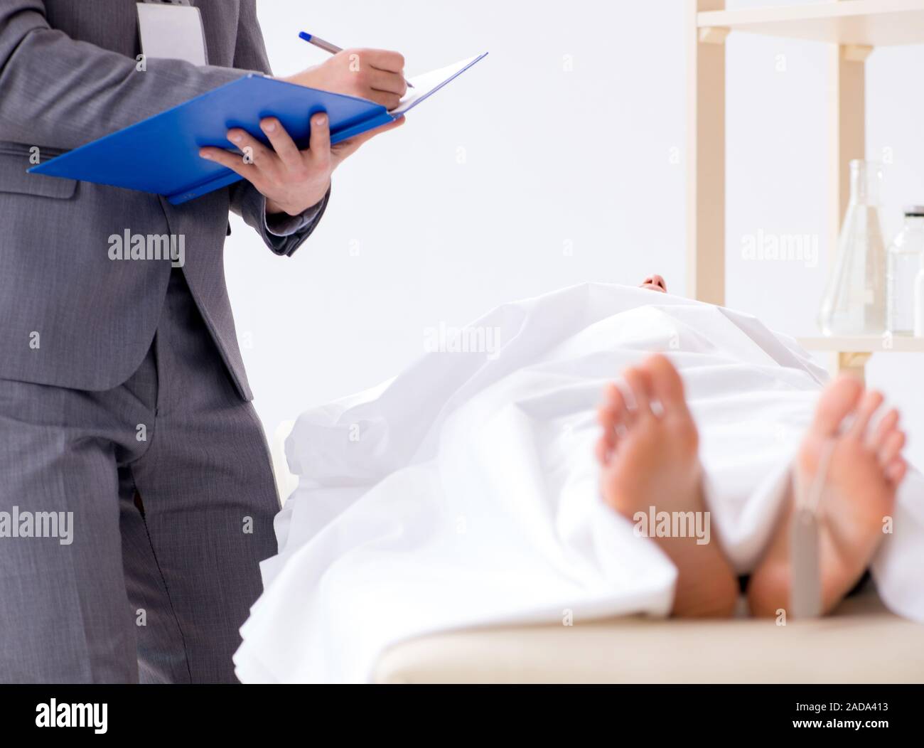 Police coroner examining dead body corpse in morgue Stock Photo