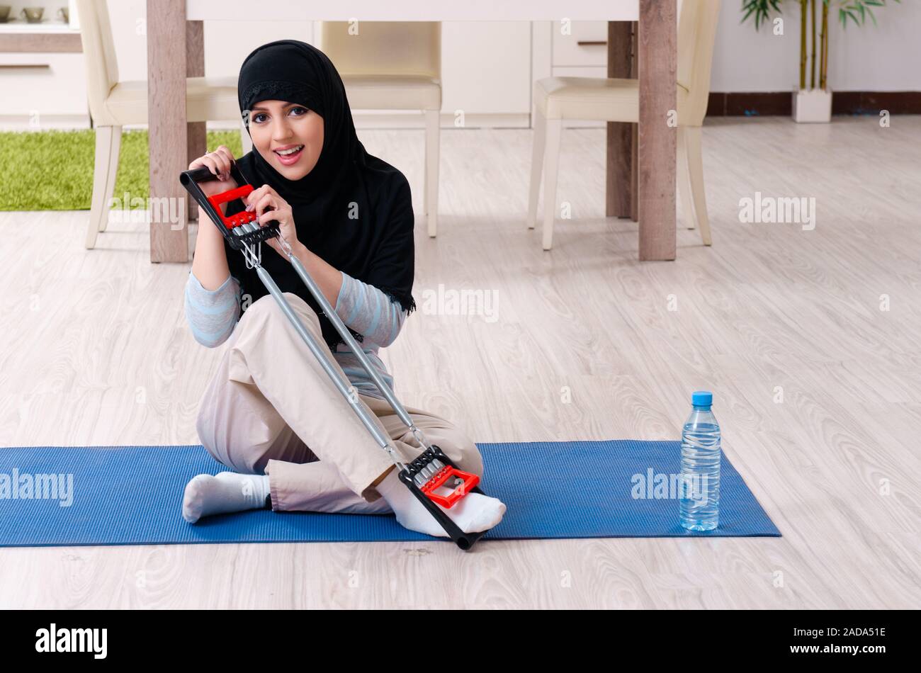 Young woman in hijab doing exercises at home Stock Photo - Alamy
