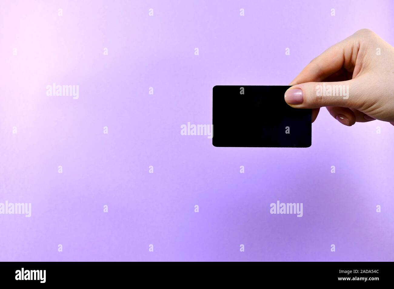 Demonstration of a black card in a hand on a purple background. Stock Photo