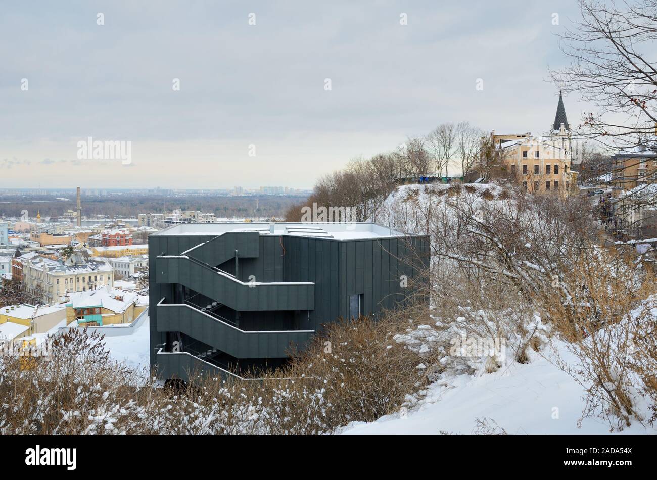 Snowy hills with a modern building of Andreevskiy Uzvoz above the borough Podol in Kyiv Stock Photo