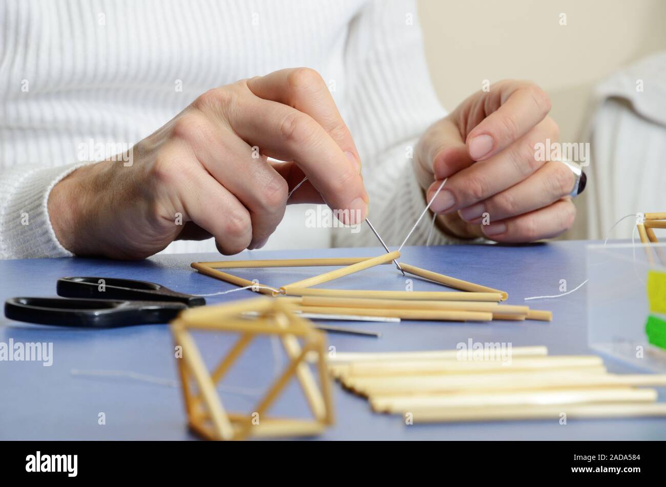 Human hands making the straw decorations named spiders or himmeli Stock Photo