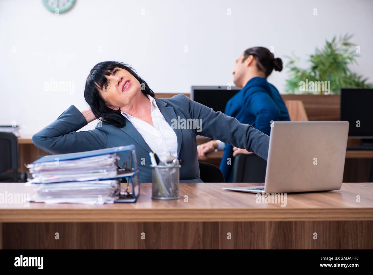 Two employees doing sport exercises in the office Stock Photo