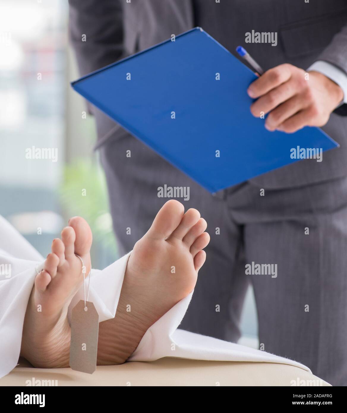 Police coroner examining dead body corpse in morgue Stock Photo