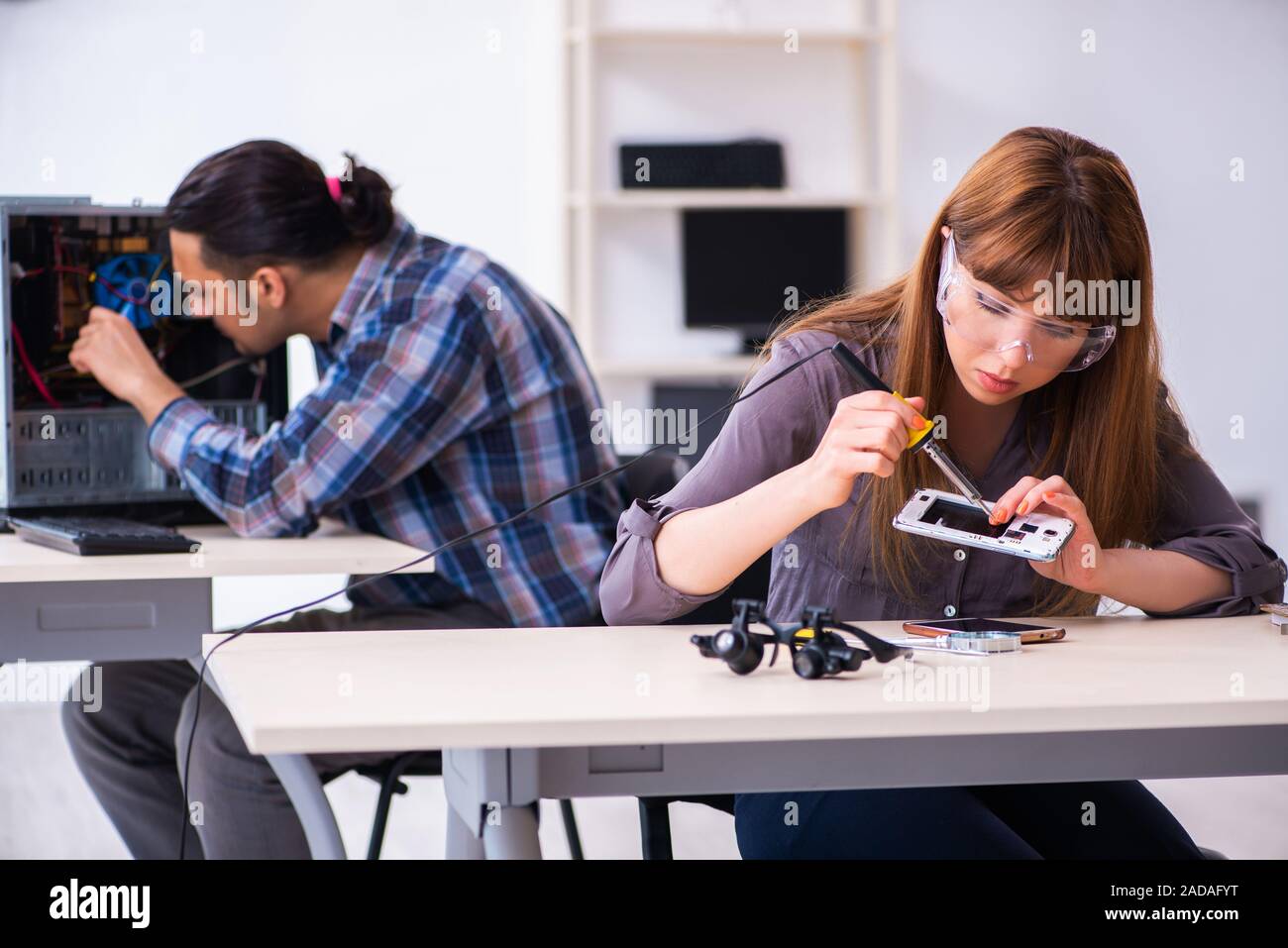 Two technicians working at computer warranty center Stock Photo