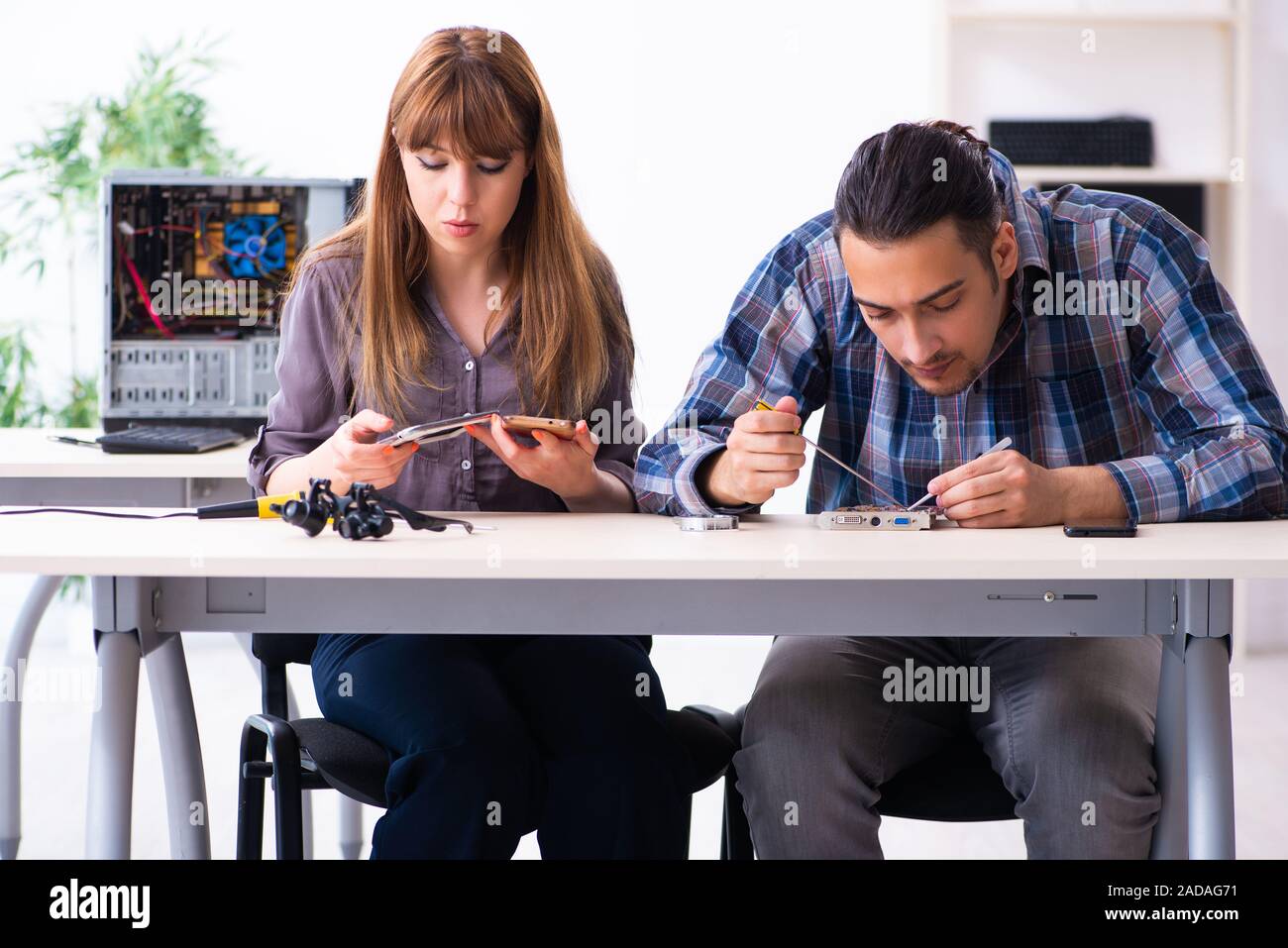 Two technicians working at computer warranty center Stock Photo