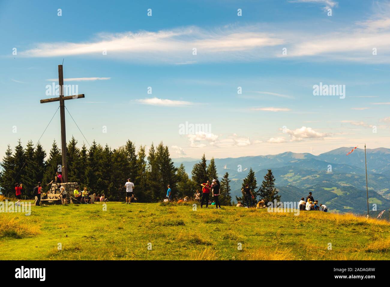 Families and tourists at the Schockl mountain next to the cross at the peak. Tourist destination Stock Photo