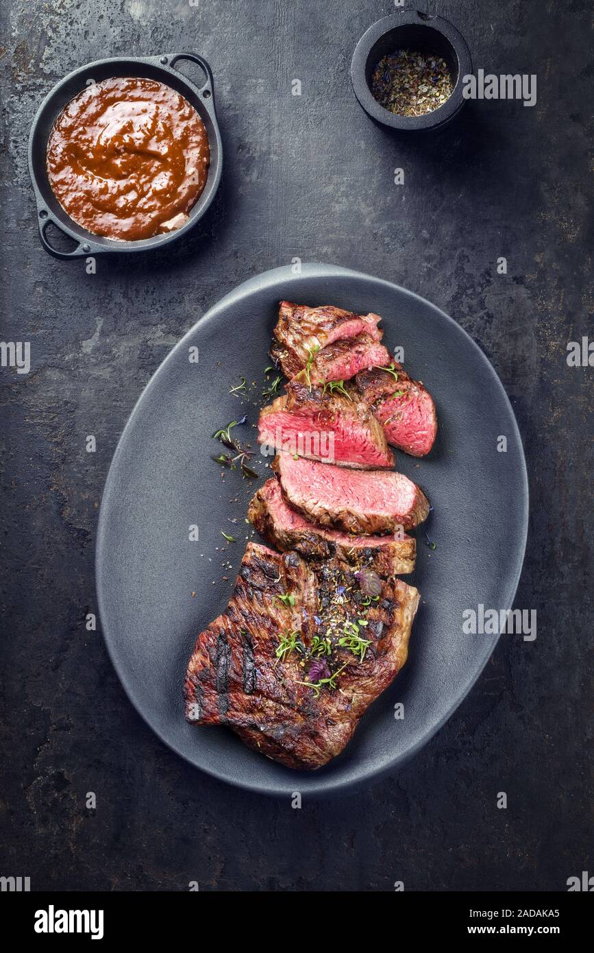 Barbecue dry aged wagyu tri tip steak sliced with hot sauce as top view