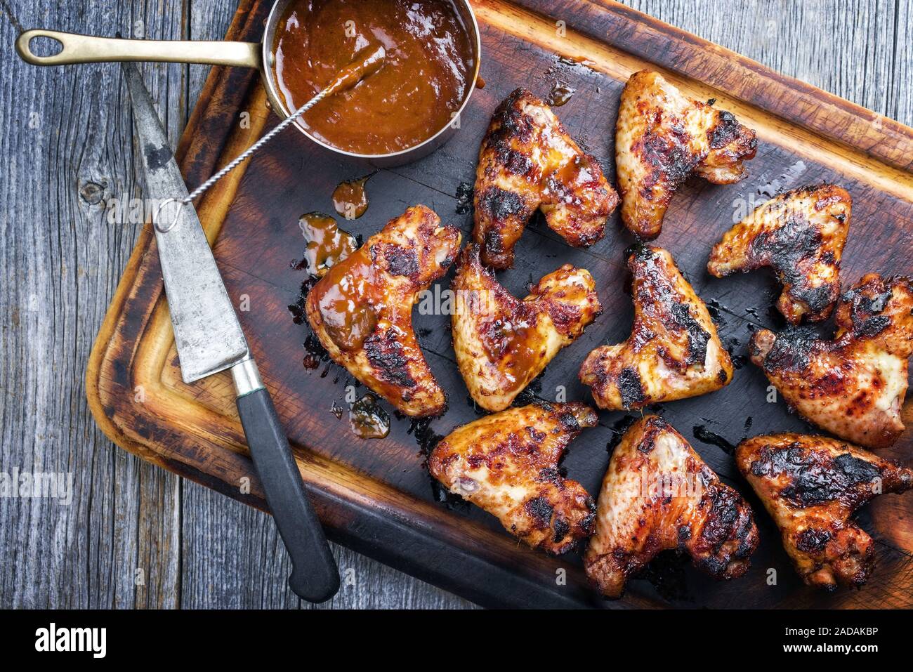 Traditional barbecue chicken wings with hot chili sauce as top view on