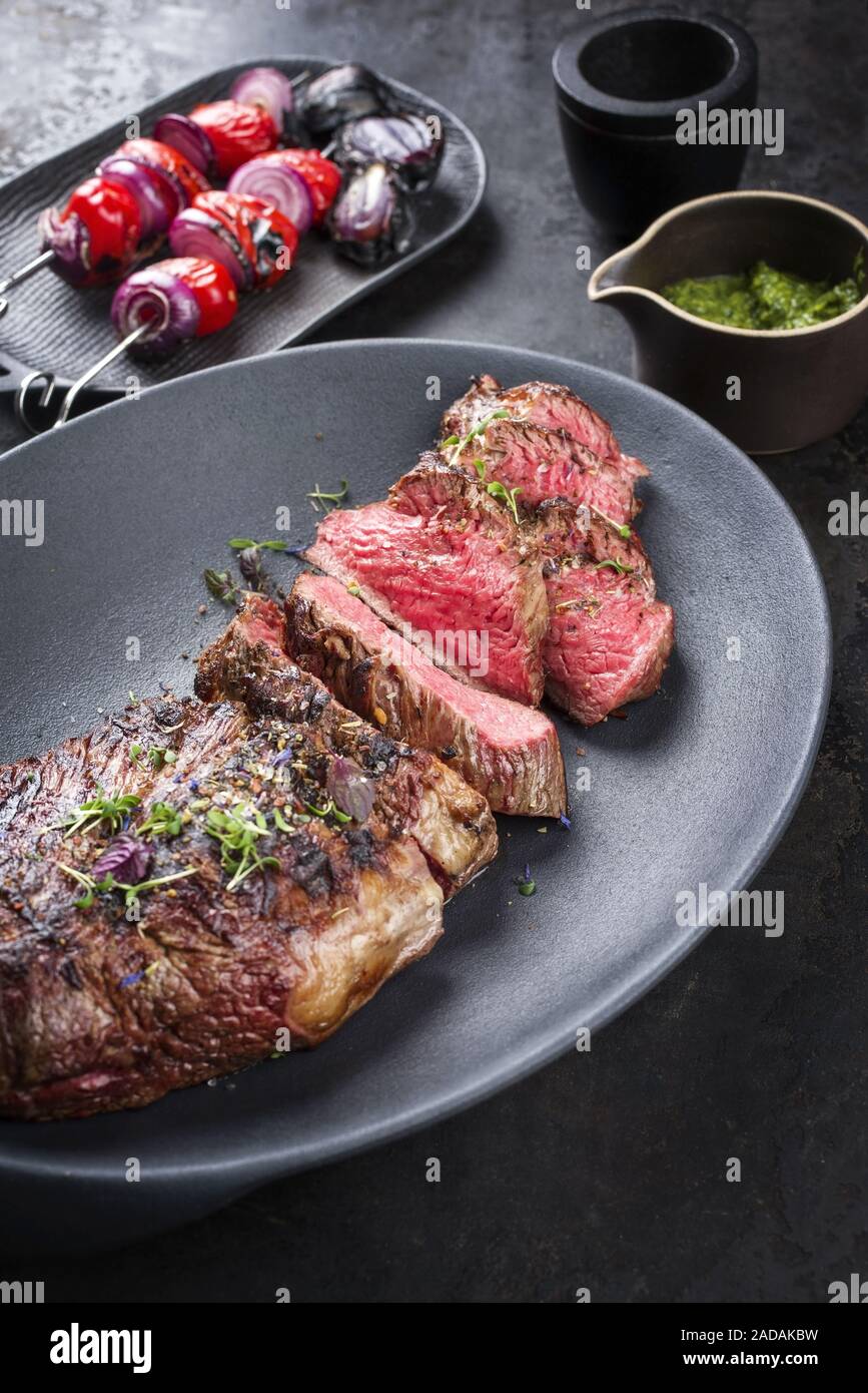 Barbecue dry aged wagyu tri tip steak sliced with hot sauce and tomato