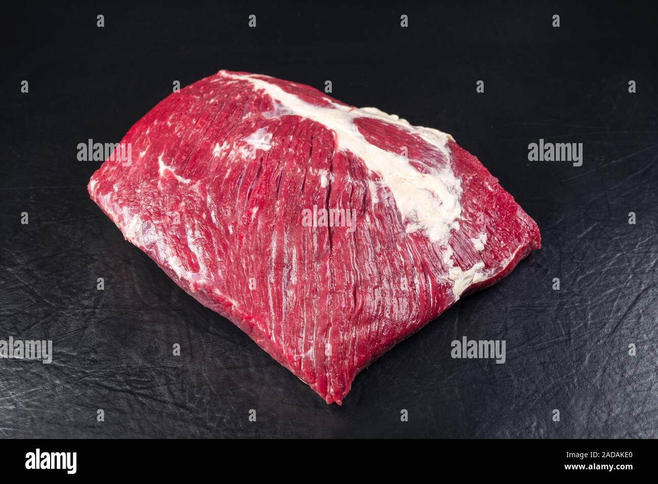 Raw wagyu bavette steak as closeup on black background with copy space