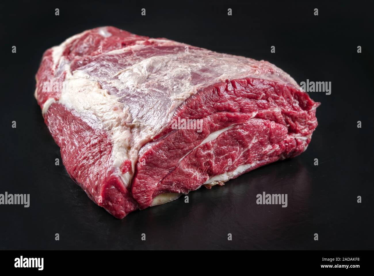 Raw dry aged wagyu beef shoulder clod roast as closeup on black background with copy space Stock