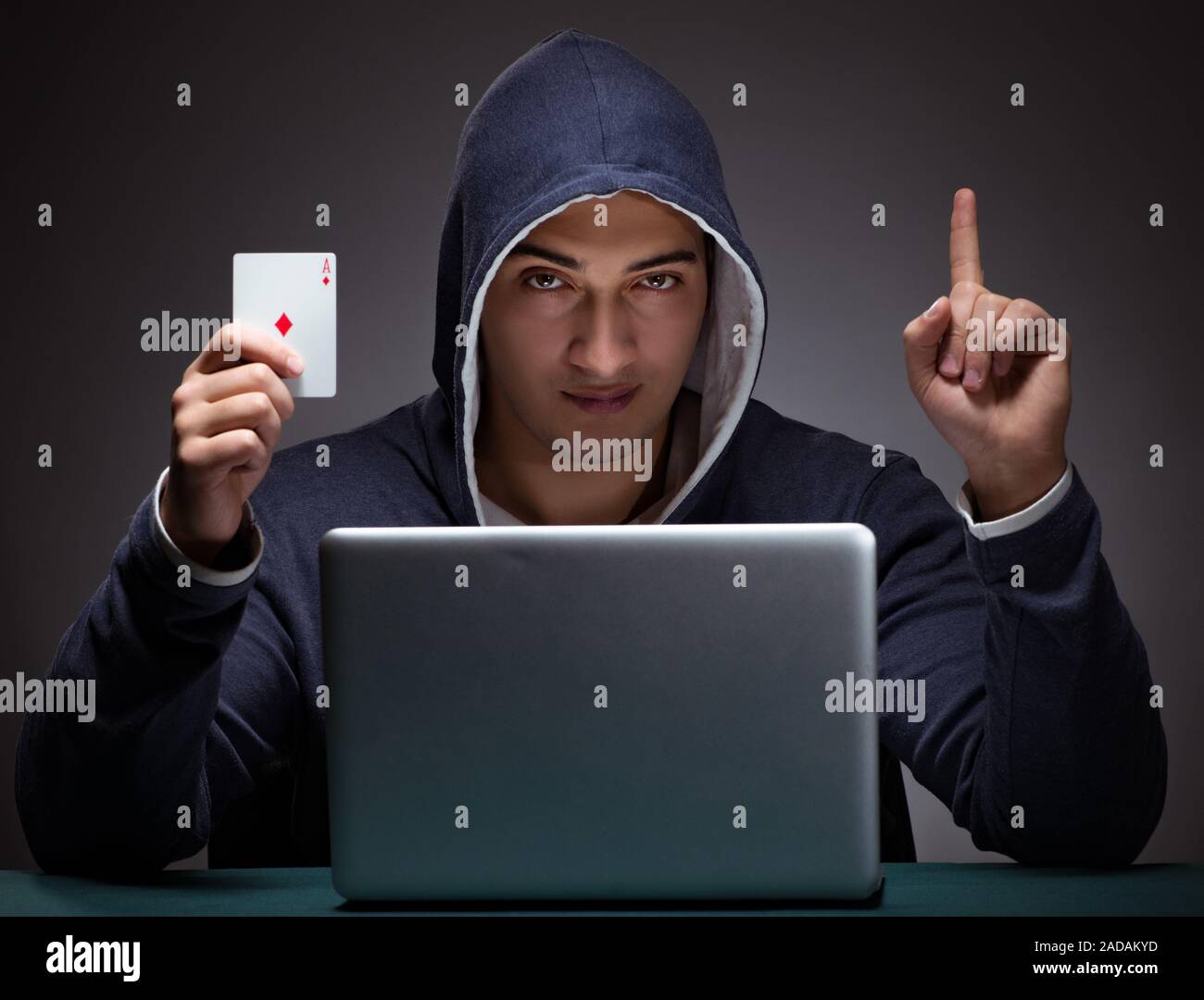 Young man wearing a hoodie sitting in front of a laptop computer Stock ...