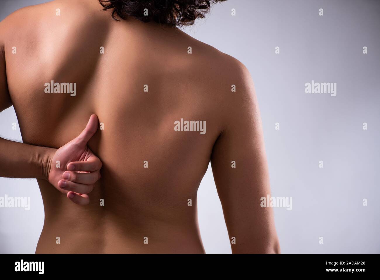 Man suffering from backbain on gray Stock Photo