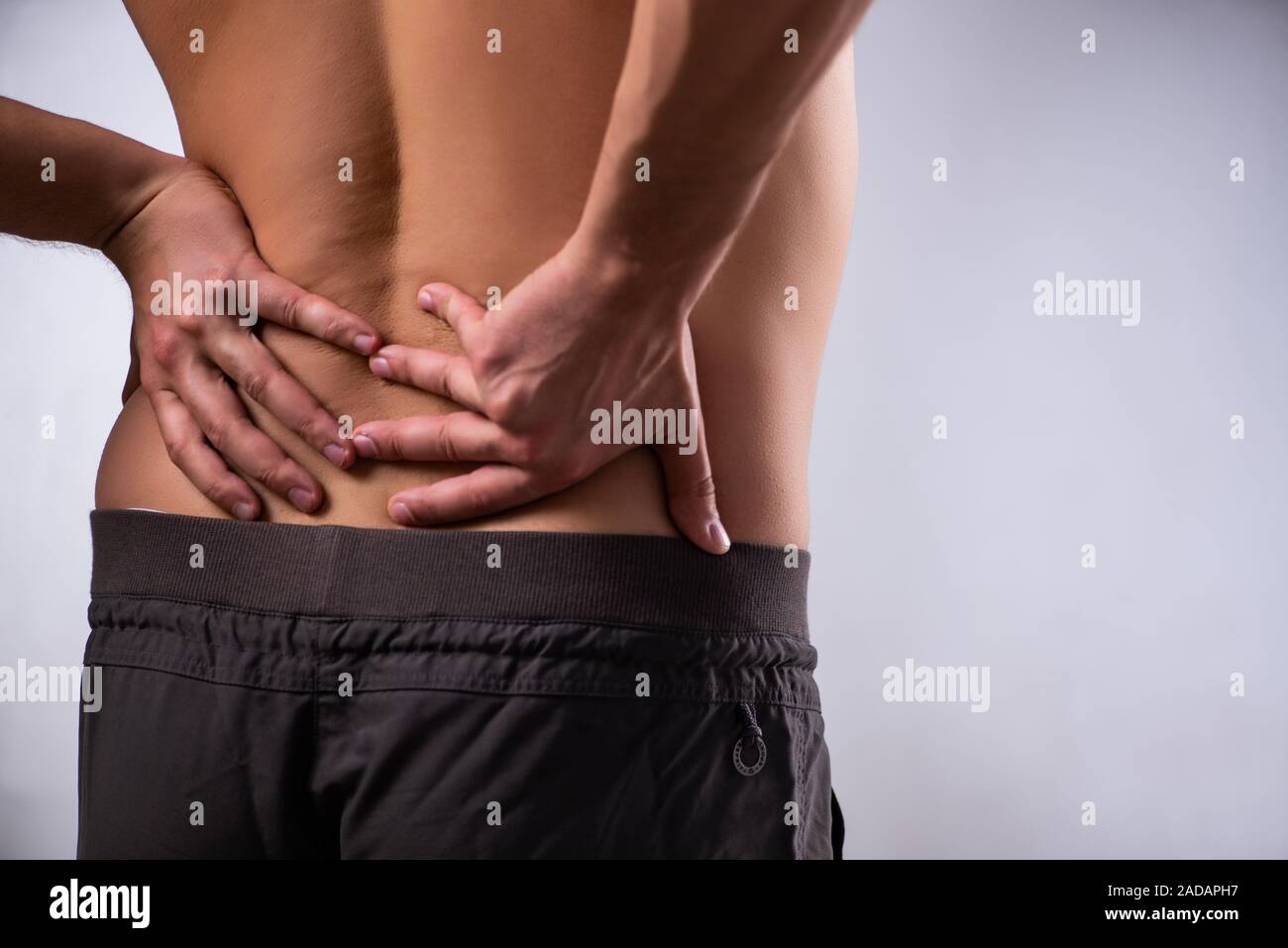 Man suffering from backbain on gray Stock Photo