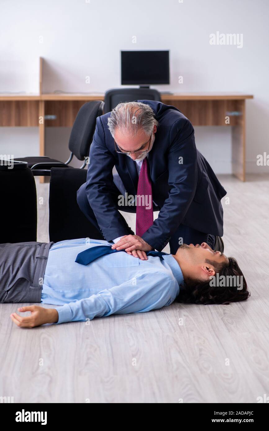 Male employee suffering from heart attack in the office Stock Photo